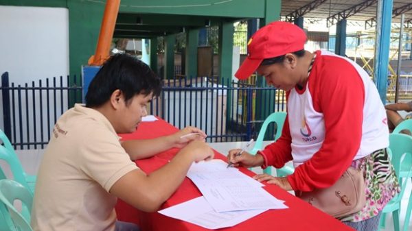 Fire victim and Tulong Panghanapbuhay sa Ating Disadvantaged Workers beneficiary Remegia Mondenedo (right) receives her wages for the 10 days’ emergency employment from Department of Labor and Employment-10 TUPAD Coordinator Julius Gonzales (left) in a payout on October 17, at Barangay Tablon, Cagayan de Oro City. (Photo courtesy of DOLE-10 CDO FO-CKMU)
